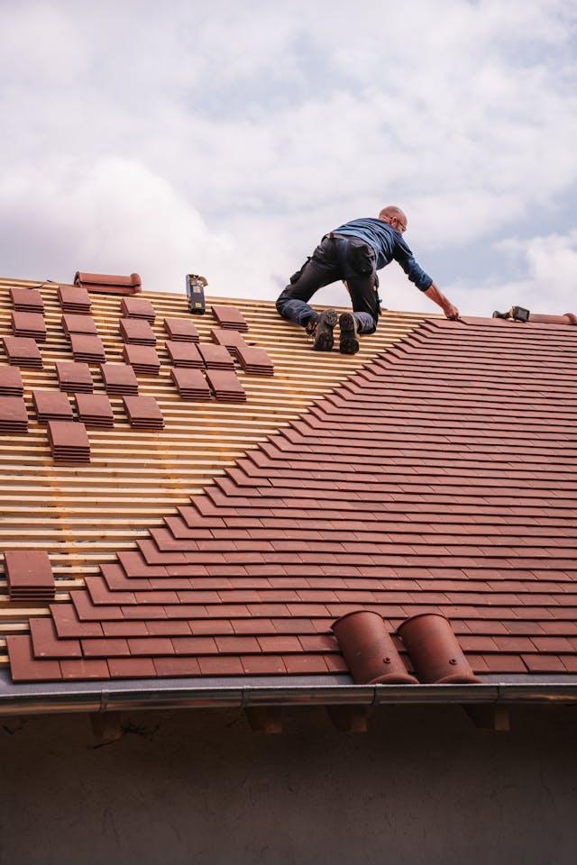 ARRT Group roofer installing clay roof tiles on a pitched residential roof